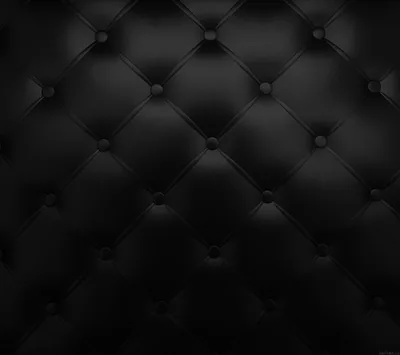 Diamond-tufted leather padding studded with buttons, lit from the top so each cushion fades into shadow toward the lower half of the frame.