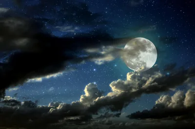 A bright moon lights torn blue clouds from the upper right, stars showing through the gaps while the lower cloud bank sinks toward black.