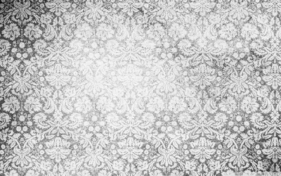 A worn damask print sits under heavy grain and light streaks, the pattern strongest in the middle and fading toward the corners.