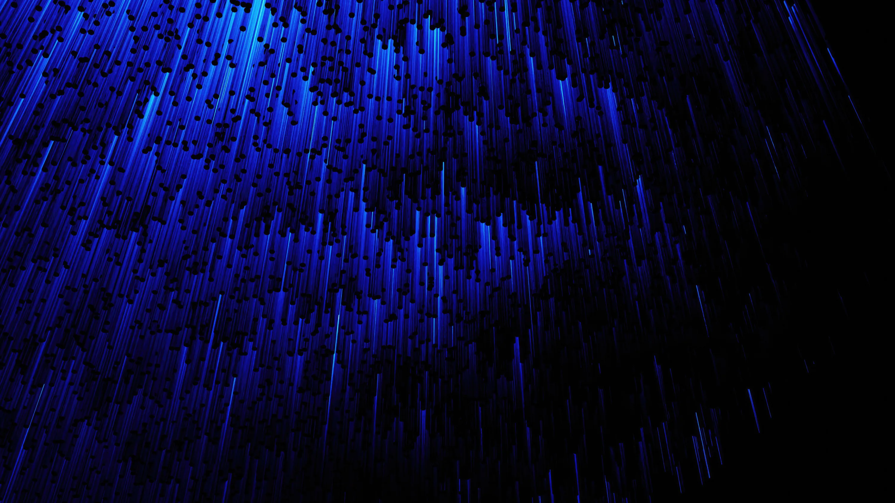 Streaks of blue light rain down at a slight angle across the left half of the frame, leaving the right side open and dark.