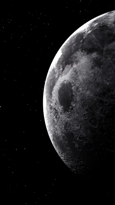 The moon hugs the right edge of the frame, its craters dissolving into shadow and leaving the whole left half black for icons.