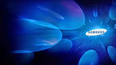 Glowing blue petal shapes radiate from a white burst on the right, where the Samsung name sits; the left third fades dark enough for desktop icons.
