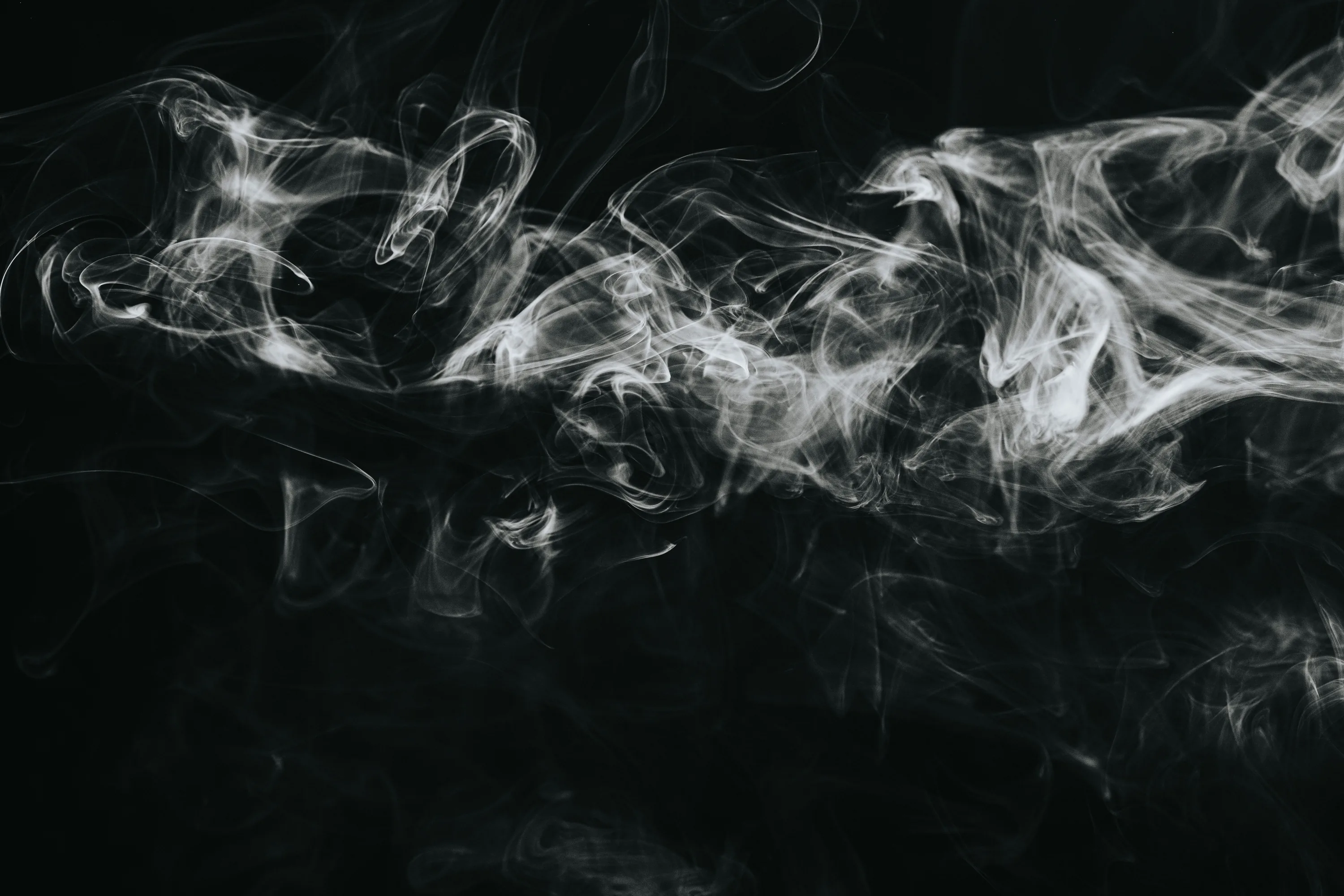 Fine white wisps tangle in a band across the upper half, leaving the whole lower third flat black for icons and dock.