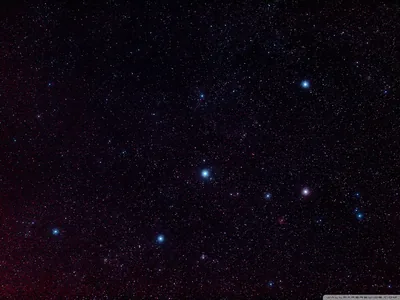 Blue and red stars scatter across a night sky washed faintly purple, a handful of brighter points catching the eye near the middle.