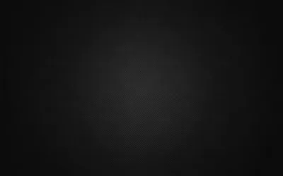 A wide charcoal surface lit softly just above centre, the tone falling away evenly into near-black across all four corners.