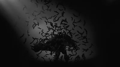 A crouched silhouette is surrounded by hundreds of bats, a shaft of pale light cutting in from the left.