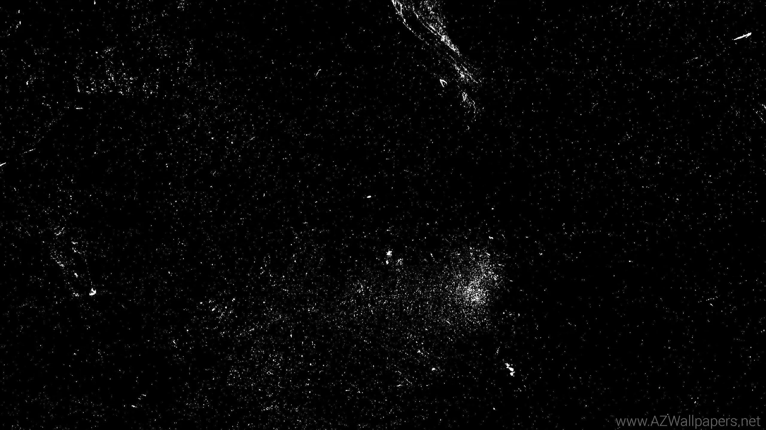 Thousands of white pinpoints spread unevenly across deep black, clustering in a bright knot at the lower centre.