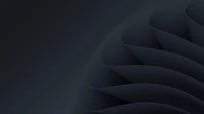 Soft charcoal ribbons fold over one another from the right edge, the left third fading to flat near-black for desktop icons.
