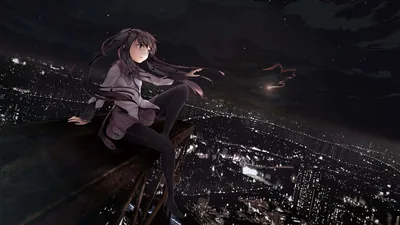 Long dark hair blows sideways as she sits on a ledge high over a lit city, the night sky above holding most of the frame.