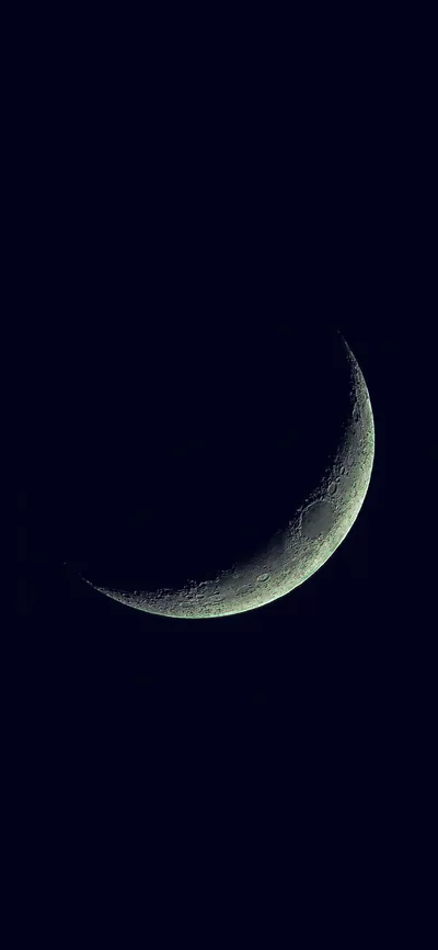 A slender crescent curves low through true black, the only light in the frame — the upper screen stays fully dark for the clock.
