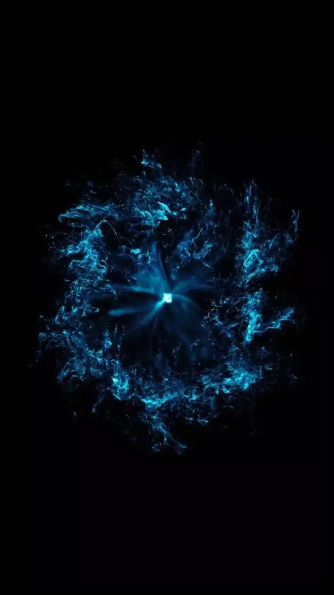 A burst of water and light scatters outward from a small bright core, the droplets breaking into fine spray against solid black.