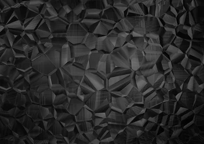 Crushed crystal facets cover the whole surface in charcoal and near-black, the largest planes catching a dull light from the upper left.