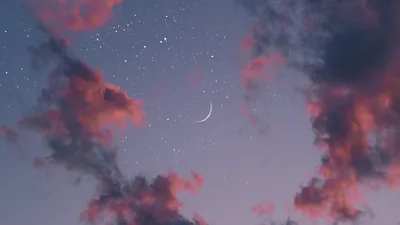 A faint new crescent floats at the centre of a grey-blue dusk, pink-lit cloud wisps pushing in from the corners under early stars.