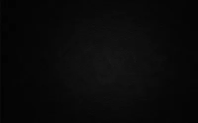 A wide circular brushing pattern turns slowly at the centre of an otherwise flat black field, visible only where the light grazes it.