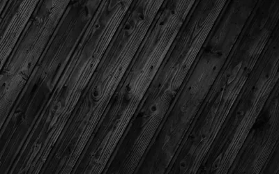 Weathered pine boards run diagonally across the frame, knots and grain picked out in grey against near-black timber.