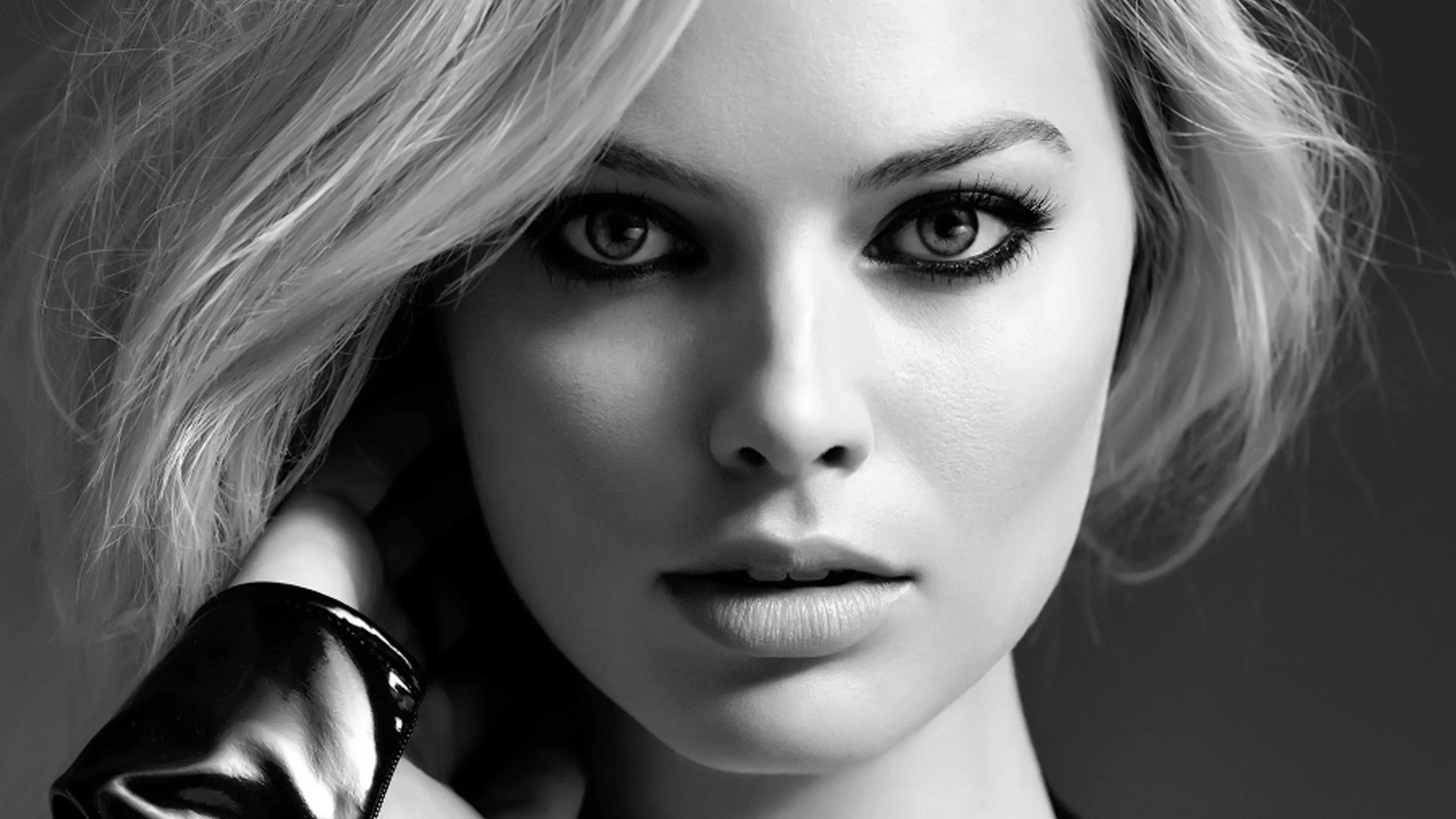 A face fills the frame in soft black and white, the eyes sharp and the hair and shoulder falling out of focus.