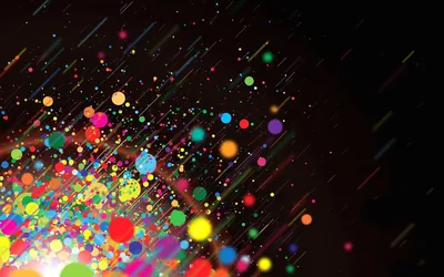 Round bokeh dots in red, yellow and green pile up in the bottom-left corner and thin out into diagonal streaks toward the dark upper right.