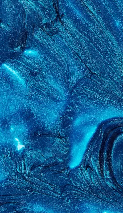 Metallic paint feathers into fern-like fronds across the frame, a bright cyan glow breaking through left of centre while the darkest navy fold curls bottom right.