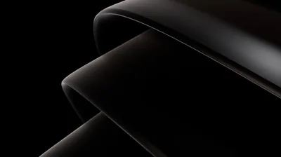 Smooth dark folds cross the frame diagonally, a single soft light running along each edge.
