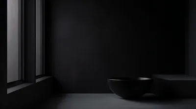 Grey daylight leaks through a window frame on the left while a matte black bowl and table sit in shadow on the right.