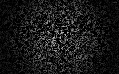 Curling vines and small blossoms radiate from the middle of the frame in dusty grey, the corners sinking into an almost solid black vignette.