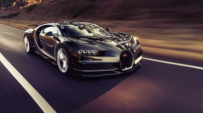 Panning shot of a black Bugatti tearing along a mountain highway, the guardrail and hillside smeared into streaks while the horseshoe grille stays razor sharp.