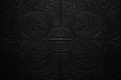 Concentric grooves form ornate medallions around a small central boss, matte black throughout, the relief readable only where light grazes the ridge tops.