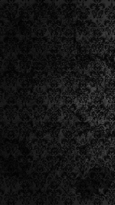 A faded damask print covers a dark wall, the pattern rubbing away in patches toward the middle of the frame.