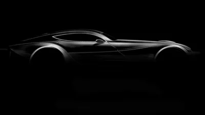 The side profile of a low sports car is drawn out of black by a single sweep of light along its roof and flank.