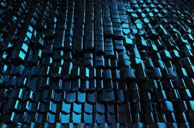Thousands of small raised cubes tilt at random angles, their tops catching a cold teal light so the field shimmers like wet slate rooftops after dark.