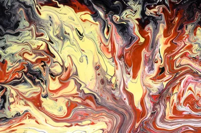 Marbled pour painting where cream and orange currents cut through charcoal, with the heaviest red pooling along the right side.