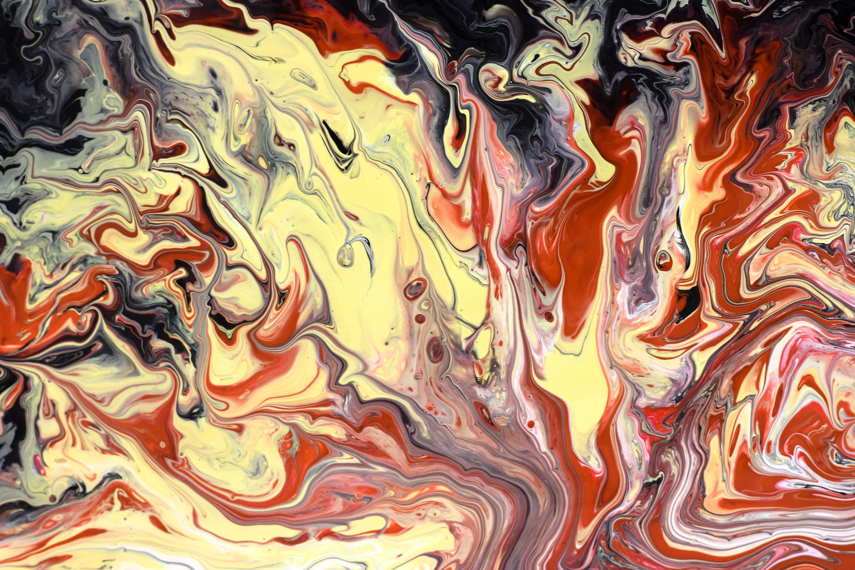Marbled pour painting where cream and orange currents cut through charcoal, with the heaviest red pooling along the right side.