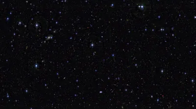 Blue-white points sit widely spaced across an otherwise empty black frame, with one tight knot of them gathered near the top left.