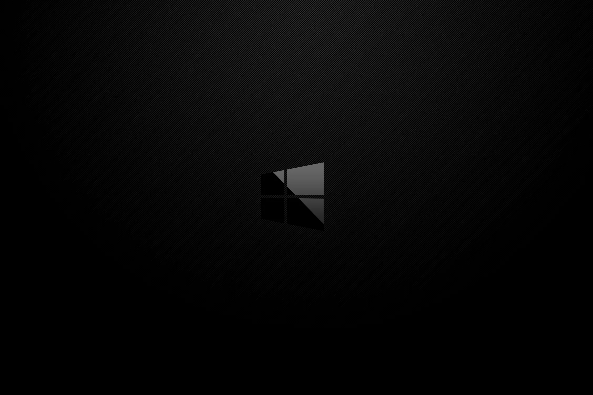 A small grey Windows mark sits alone in the middle of a soft black gradient, everything else left clear.