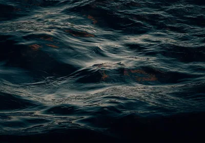 Low light skims across slow black-green swells, an almost abstract water texture that sits comfortably behind desktop icons.