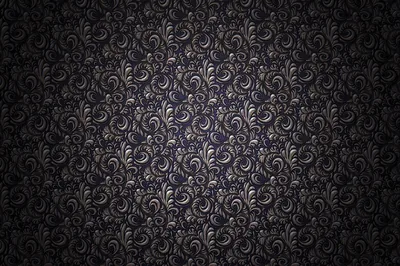Tightly packed flourishes in pewter cover a violet-black ground, sharpest and brightest at dead centre, a heavy vignette dragging all four corners down to black.