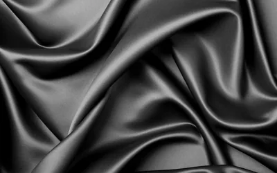 Smooth charcoal satin gathered into diagonal folds, the sheen running brightest through the upper left while the lower folds settle into soft grey shadow.