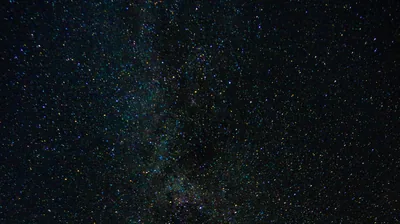 The Milky Way rises straight up through a muted teal sky, its dust lane darker than the fine stars packed around it.
