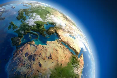 A raised-relief globe with exaggerated mountains and bright green lowlands, tilted so Europe, the Sahara and the Red Sea fill the frame edge to edge.