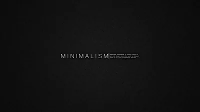 Wide-spaced letterforms sit centred on a finely grained charcoal background with a small paragraph of grey text beside them.