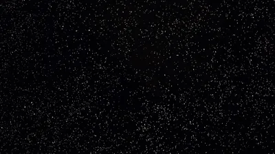 Tiny white specks scattered like dust over solid black, thickest through the centre and clearing toward the corners.
