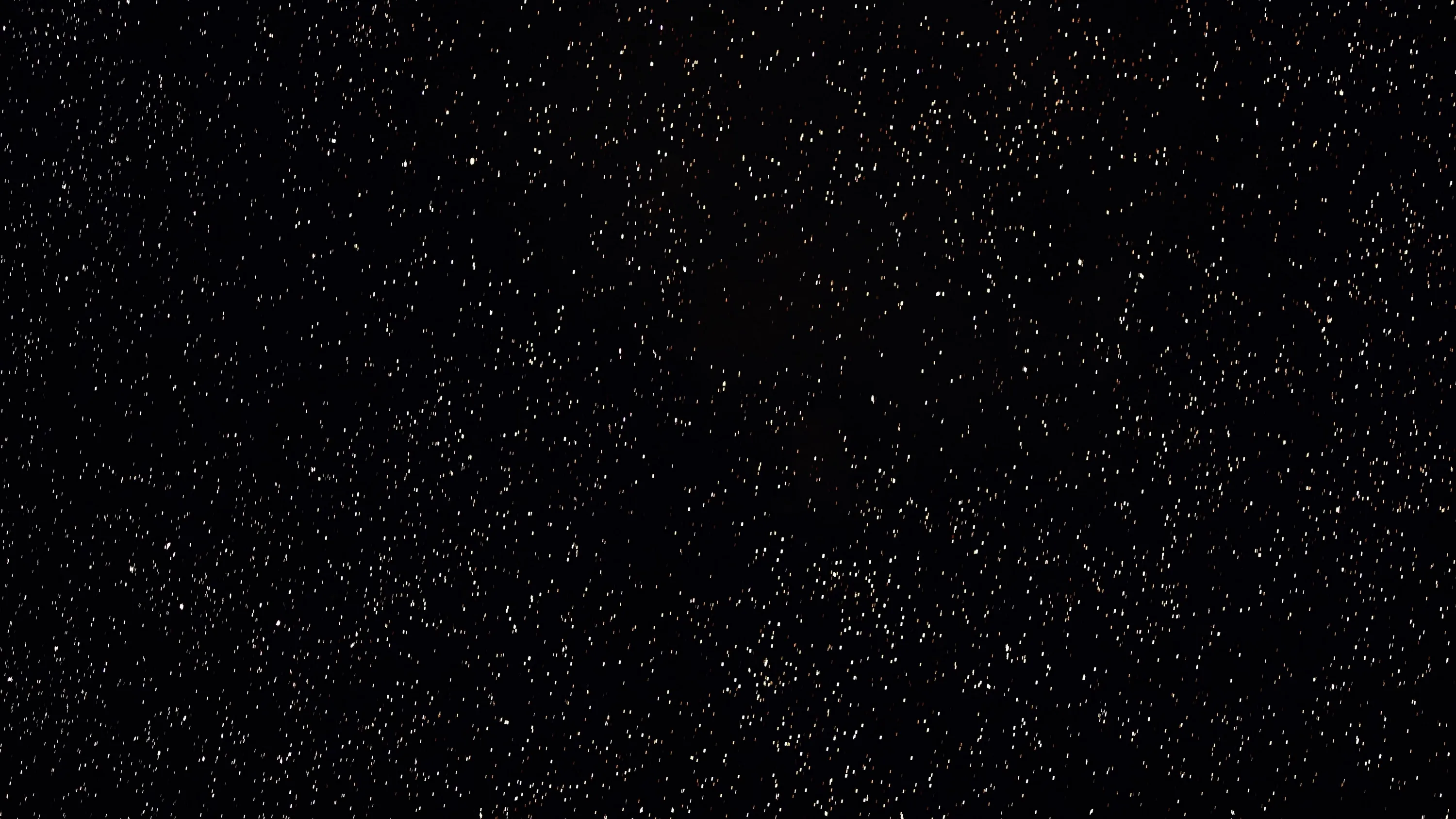 Tiny white specks scattered like dust over solid black, thickest through the centre and clearing toward the corners.