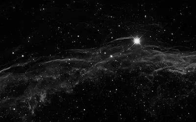 One star flares near the top right above long, thread-like nebula wisps that sweep across the lower half in grey.