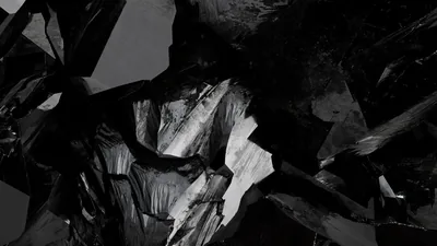 Broken shards catch a hard sidelight against near-black, the sharp white highlights running down the middle of the frame.