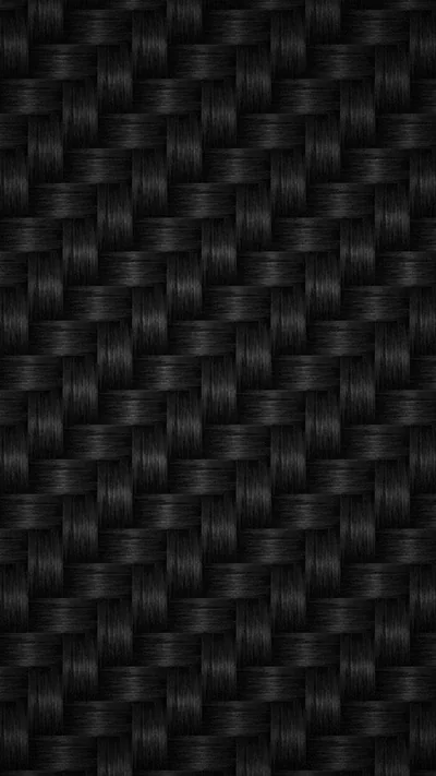 A tight basket weave of black fibres fills the frame, side lighting picking out the raised strands and dropping the gaps to near black.