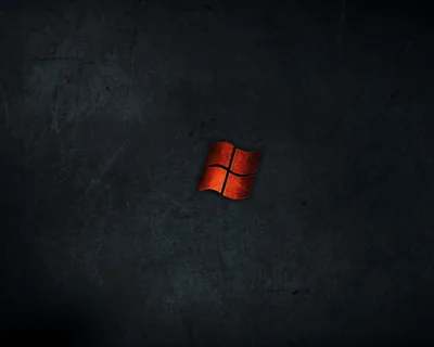 A small rust-red Windows logo sits alone at the centre of a scratched slate wall, leaving the whole outer frame free for icons and widgets.