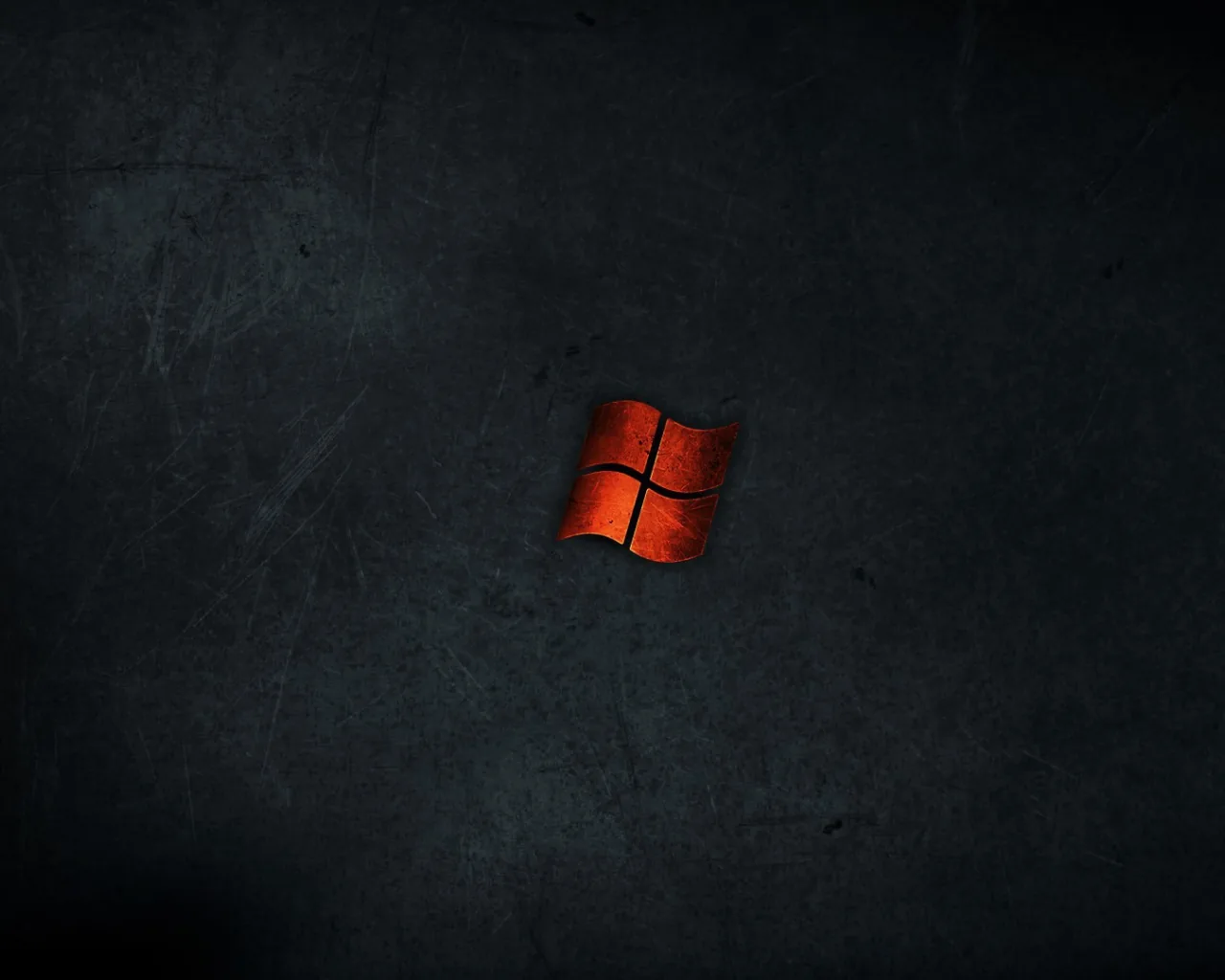 A small rust-red Windows logo sits alone at the centre of a scratched slate wall, leaving the whole outer frame free for icons and widgets.