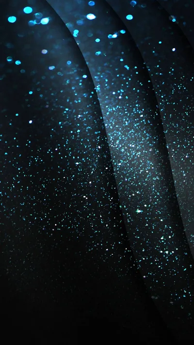 Specks of blue glitter scatter across diagonal folds of near-black fabric, densest along the left seam while the lower-right corner stays plain dark.