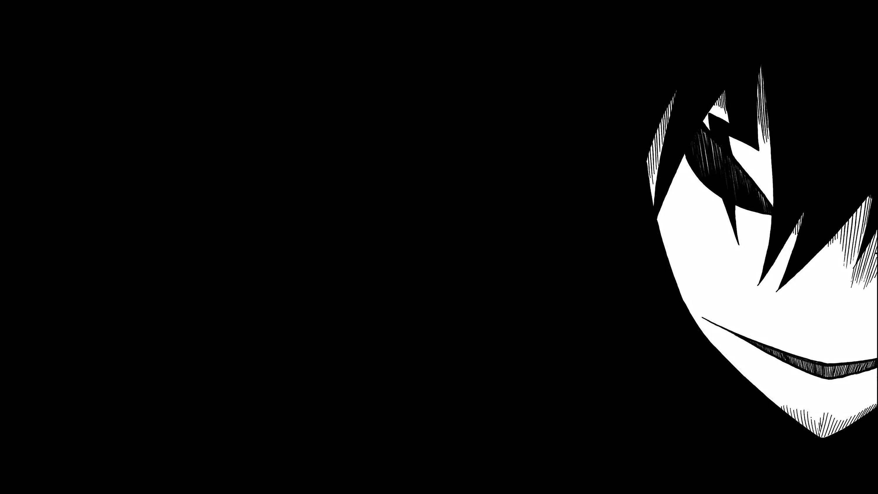 Half a grinning face sits hard against the right edge in stark black and white, the remaining two thirds of the frame solid black.