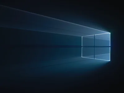 Pale beams stretch back into deep blue-black space and resolve into the four-pane Windows mark on the right, the left half left empty.